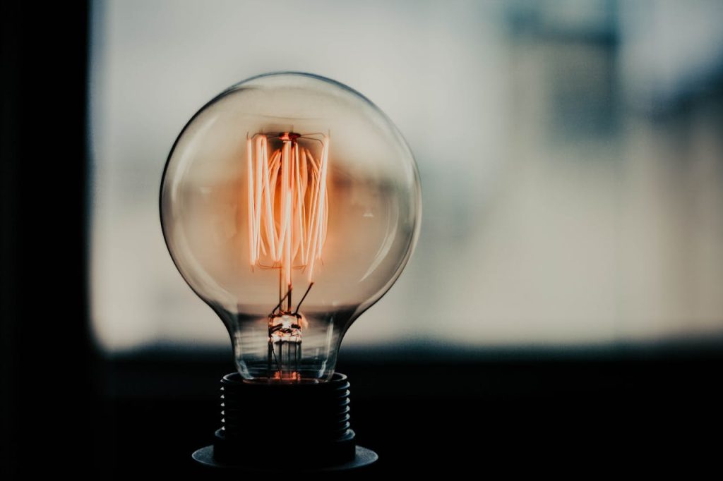 A glowing vintage filament bulb showcasing intricate details of its internal structure. Captivating and artistic.